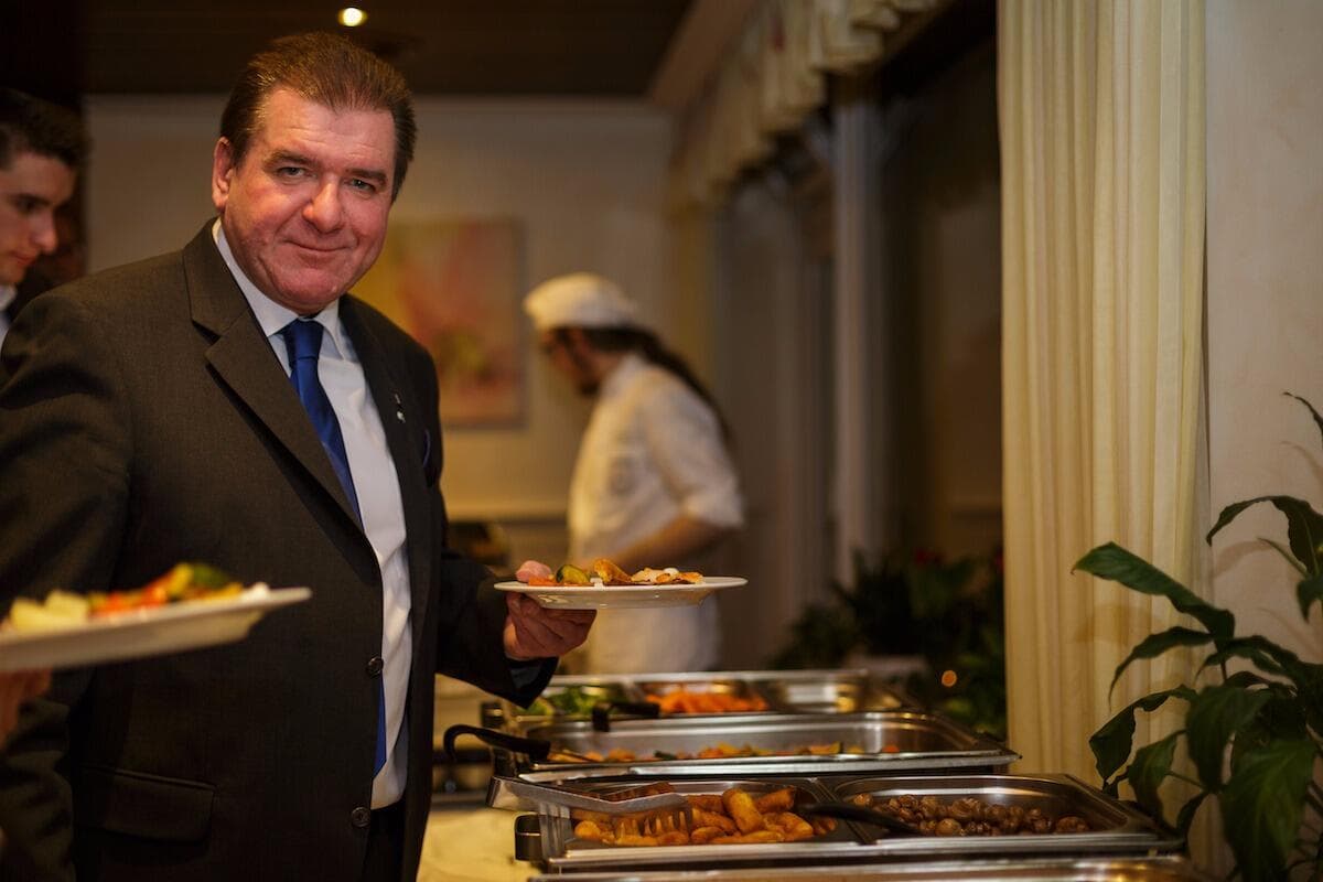Gastgeber am warmen Buffet